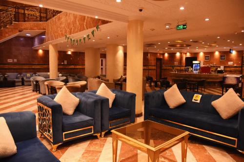 a lobby with blue couches and a bar at Al Andalus Palace 1 Hotel in Al Madinah