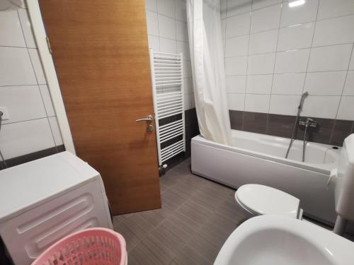 a bathroom with a toilet and a sink and a tub at Apartment Mejdan in Tuzla