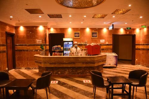 a bar in a restaurant with tables and chairs at Al Andalus Palace 1 Hotel in Al Madinah