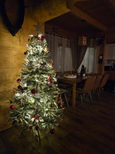 a christmas tree in a room with a table at Góralska Chatka 3 Highland Cottage - Jacuzzi, Sauna, Split AC, Private parking, Mountains View in Zakopane