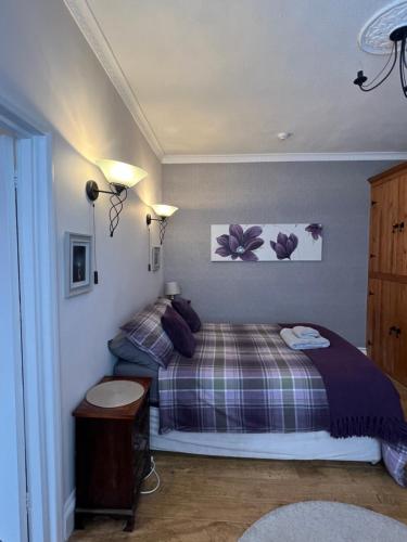 a bedroom with a bed and two pictures on the wall at Sandford House Den in Seaford