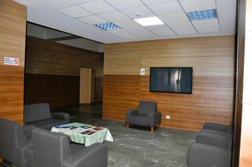 a waiting room with chairs and a table and a tv at Arena Hotel Goygol in Xanlar