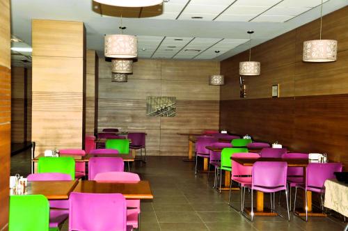 a dining room with purple and green chairs and tables at Arena Hotel Goygol in Xanlar