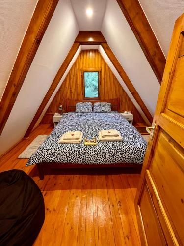a bedroom with a bed in a attic at Kerekerdő Apartman - Szarvaskő in Szarvaskő