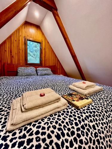 a bedroom with a bed with a black and white comforter at Kerekerdő Apartman - Szarvaskő in Szarvaskő
