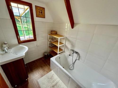 a bathroom with a sink and a bath tub and a sink at Kerekerdő Apartman - Szarvaskő in Szarvaskő