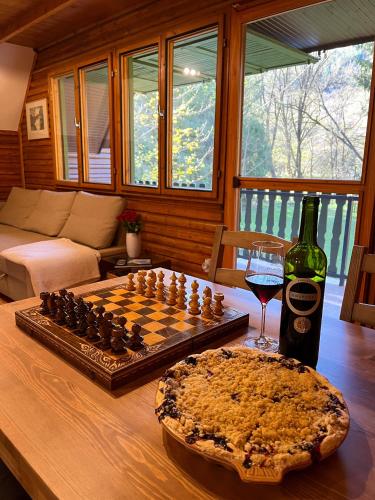 a chess board and a glass of wine on a table at Kerekerdő Apartman - Szarvaskő in Szarvaskő