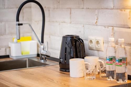 eine Kaffeemaschine auf einer Theke neben einem Waschbecken in der Unterkunft My Home Apart in Berehowe