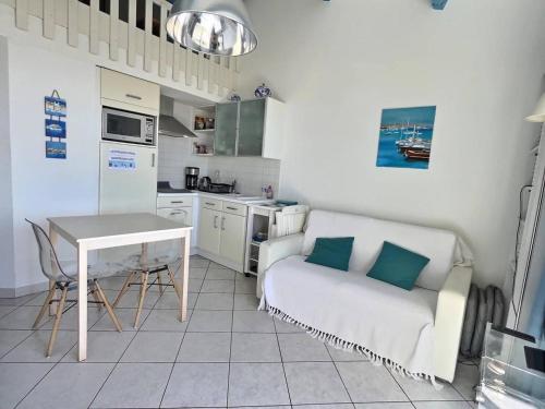 a kitchen with a couch and a table in a kitchen at Appartement vue mer en plein centre de Valras-Plage in Valras-Plage