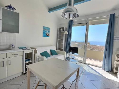 a kitchen and living room with a table and a window at Appartement vue mer en plein centre de Valras-Plage in Valras-Plage
