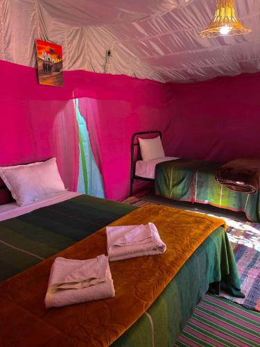 a pink room with two beds in a tent at Bivouac Lot Of Stars in Ouarzazate