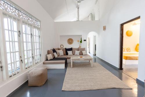a living room with a couch and a table at Coconut Cottage - Hiriketiya Beach in Hiriketiya