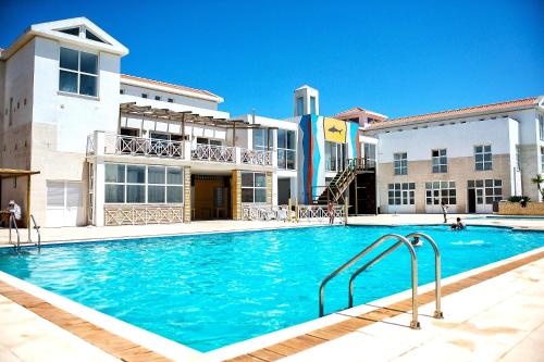 a large swimming pool in front of a building at Shark's Lodge in Baleal