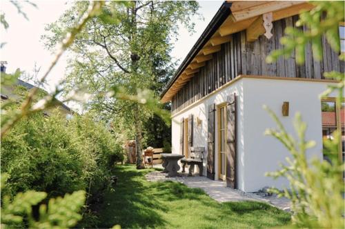 una casa con un banco delante de un patio en DIE ZWEI CHALETS AM TEGERNSEE "s' Gloane" & "s' Große" en Rottach-Egern