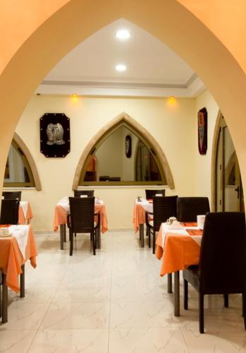 a dining room with tables and chairs and an archway at Castello Di Cavallieri Suites & Spa - Adults Only in Faliraki