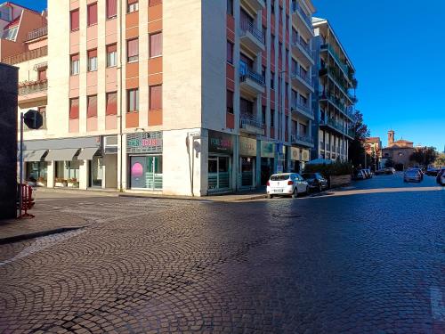 uma rua vazia com um carro branco estacionado em frente a um edifício em Orchidea Home em Busto Arsizio