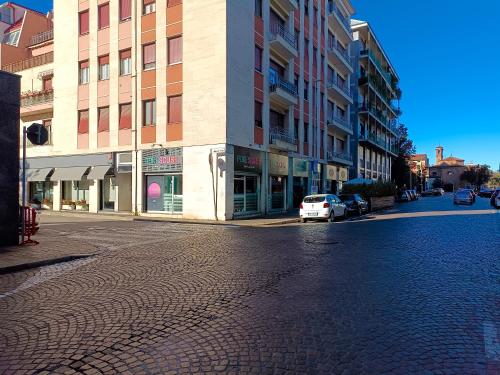 una calle vacía con un coche blanco estacionado frente a un edificio en Orchidea Home, en Busto Arsizio