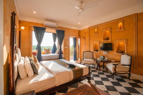 een slaapkamer met een groot bed en een tafel en stoelen bij Hotel Helsinki House in Jaisalmer