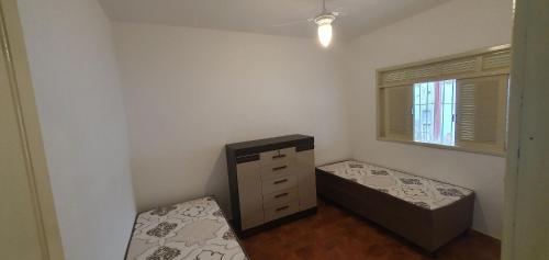 1 dormitorio con 1 cama, vestidor y ventana en Casa Temporada Guriri Céu Azul, en Guriri