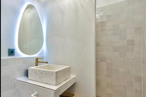 une salle de bain avec un lavabo et un miroir dans l'établissement Proche du Vieux-Port, avec balcon, à Marseille