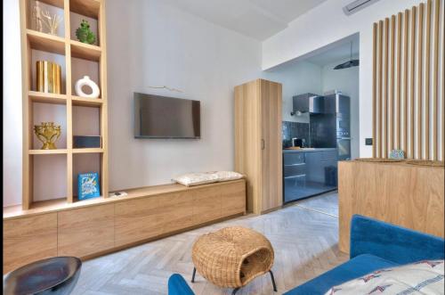 un salon avec une télévision sur un mur dans l'établissement Proche du Vieux-Port, avec balcon, à Marseille