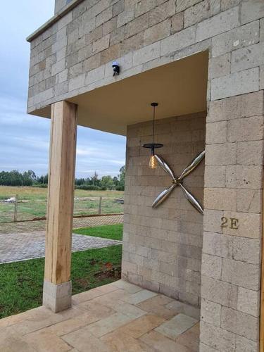 a stone wall with a clock on it at The Landing Cottages in Nanyuki