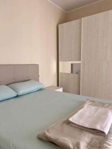 una camera bianca con un letto e un asciugamano sopra di Sea View Apartment Anabel a Vlorë