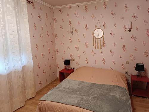 a bedroom with a bed and a clock on the wall at La maison de mamie rdc 