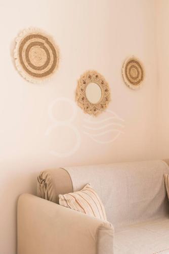 a living room with a couch and three wreaths on the wall at 8 Homes in Meganisi
