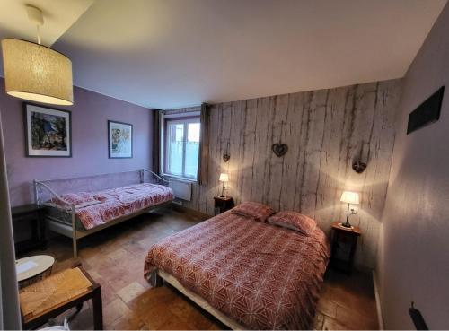 ein Schlafzimmer mit einem Bett, zwei Tischen und zwei Lampen in der Unterkunft La Gouline in Gréez-sur-Roc