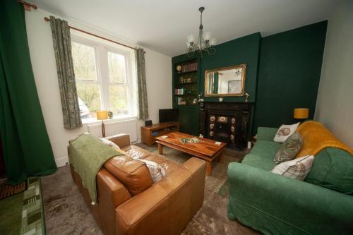 a living room with two couches and a table at Heron's Rest in Cressbrook