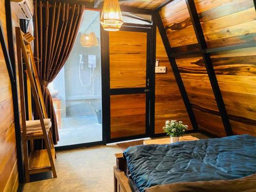 a bedroom with a bed and a glass door at Tiên Sơn Pleiku Homestay in Pleiku