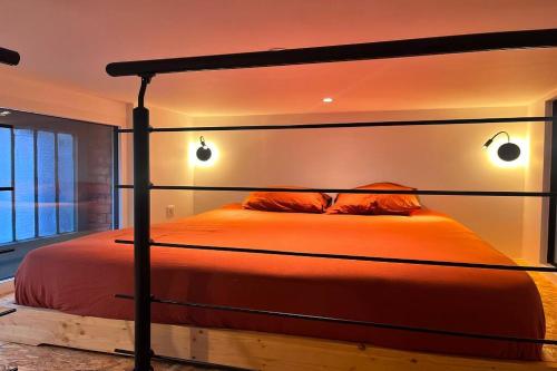 - une chambre avec un lit orange et 2 oreillers dans l'établissement Appartement indép cosy avec jardin, à Saint-Denis