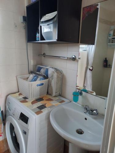 a bathroom with a washing machine and a sink at Anastasia's garden house in Ialyssos