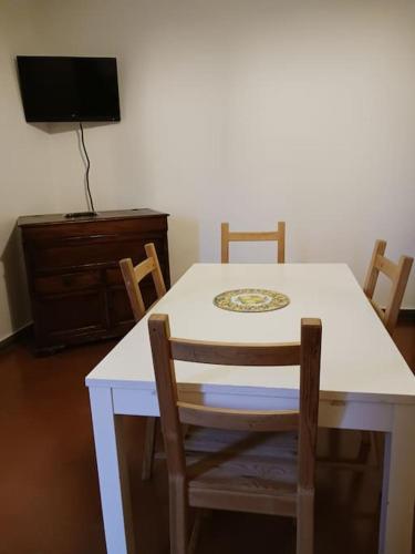 a dining room table with chairs and a tv at Casa vacanza Raffaela in Gubbio