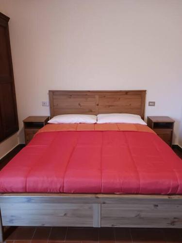 a bed with a red bedspread on top of it at Casa vacanza Raffaela in Gubbio