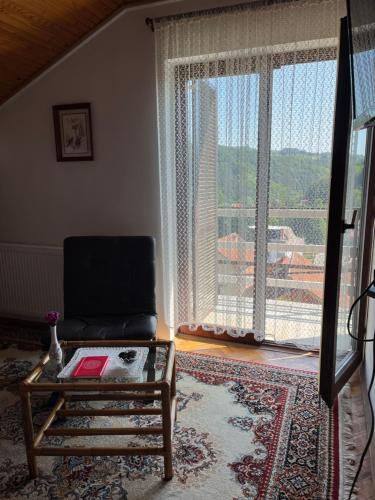 - un salon avec un canapé et une grande fenêtre dans l'établissement Zelena Oaza Krupanj, à Krupanj