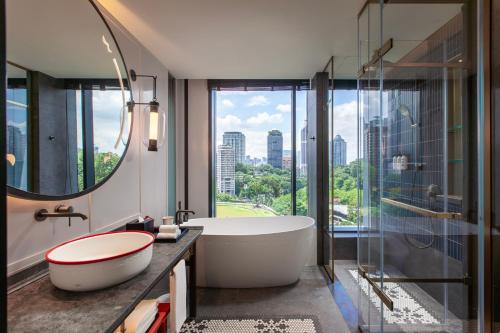 a bathroom with a tub and a large window at Hotel Indigo Kuala Lumpur on the Park by IHG in Kuala Lumpur