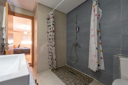 a bathroom with a shower with a shower curtain at Appartement en résidence avec piscine in Agadir