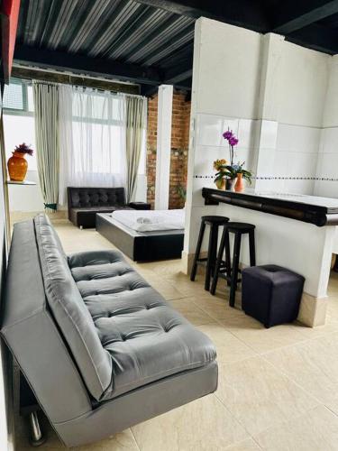 een woonkamer met een bank en een piano bij Villa tikuna in Mariquita