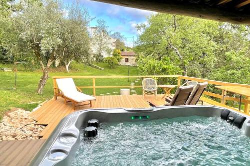 bañera de hidromasaje en una terraza con 2 sillas en Casa do Vale do Papo, en Pombal