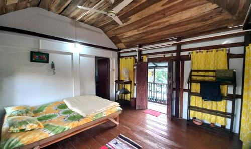 una camera con letto in una stanza con soffitti in legno di Oronner Din Ratri a Sreemangal