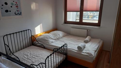 a small bedroom with a bed and a window at Bobrovia Apartment in Warsaw