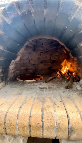 a pizza is cooking in a brick oven at Stone Maisonettes in Aígio