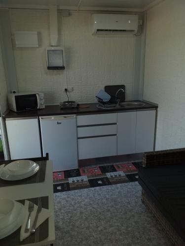a kitchen with white cabinets and a counter top at Camping las Catalinas in Ríolobos