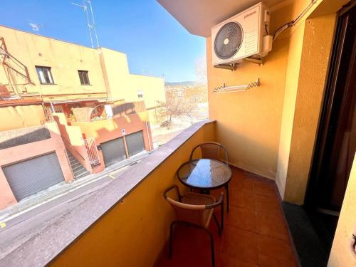 balcón con mesa, sillas y ventana en MT Nuevos Apartamentos y Suites con baño privado, en Mataró