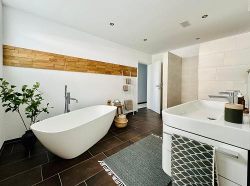 a bathroom with a large white tub and a sink at Haus am Bodensee mit Sicht - Stilvoller Luxus in Ermatingen