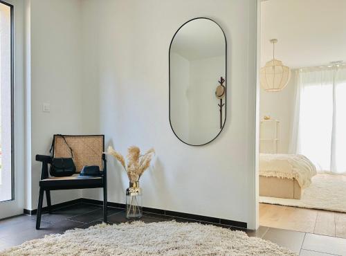 a room with a mirror and a chair and a rug at Stylisches Ferienhaus bis 6 Gäste mit einzigartigem Seepanorama in Ermatingen