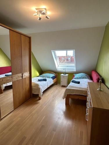 Cette chambre comprend 2 lits et une fenêtre. dans l'établissement Loft mit 2 Terrassen - ruhig&sonnig, à Leipzig