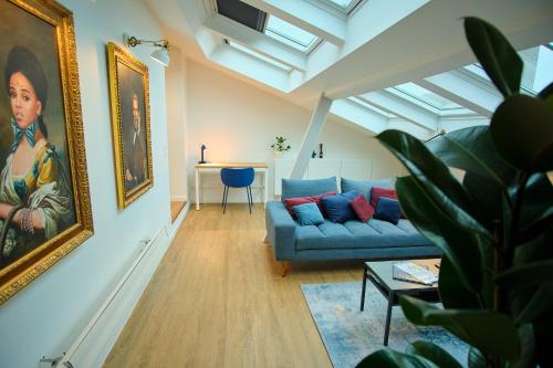 a living room with a blue couch and a painting at Le Louis XVI - Loft in the clouds in the heart of Nancy in Nancy